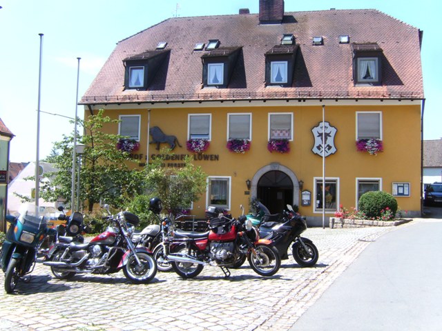 Mehrere Motorräder parken an einem sommerlichen Tag vor dem Gasthof " zum goldenen Löwen" in Moosbach.