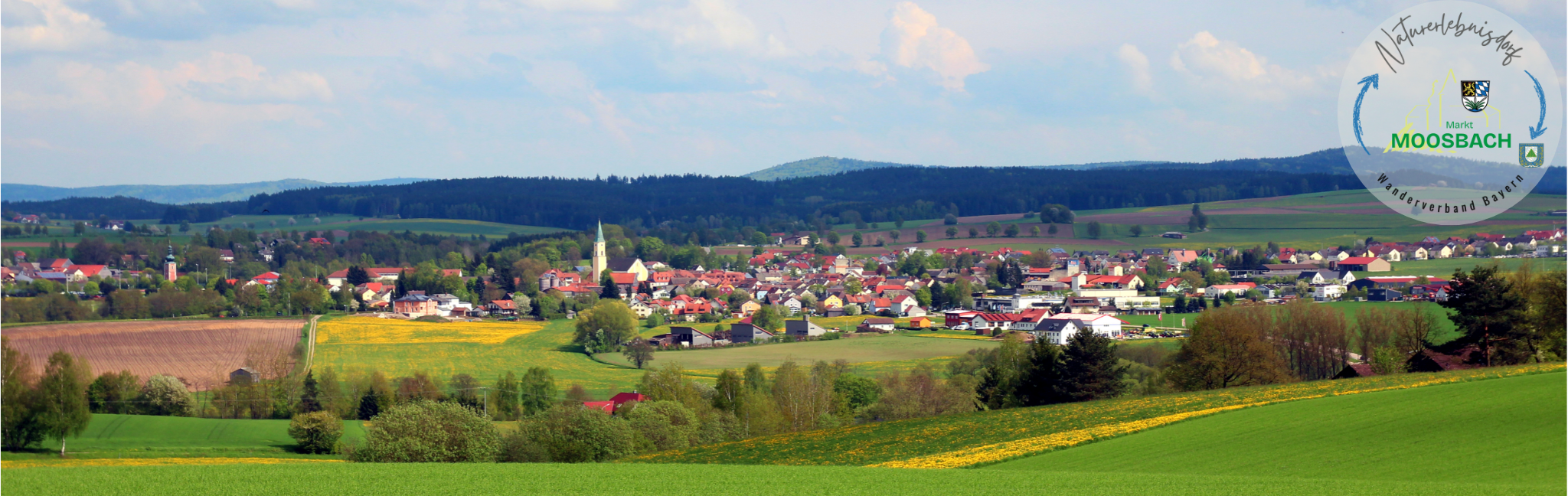 NaturerlebnisdorfMoosbach Panoramaaufnahme von Moosbach mit der Silhouette des Marktes umgeben von freier Natur mit Wäldern, Wiesen und Feldern