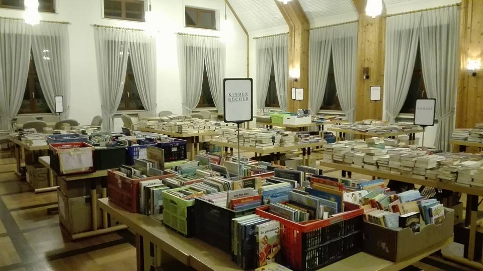 Bücherbasar im Rathaussaal mit Büchern auf den Tischen.