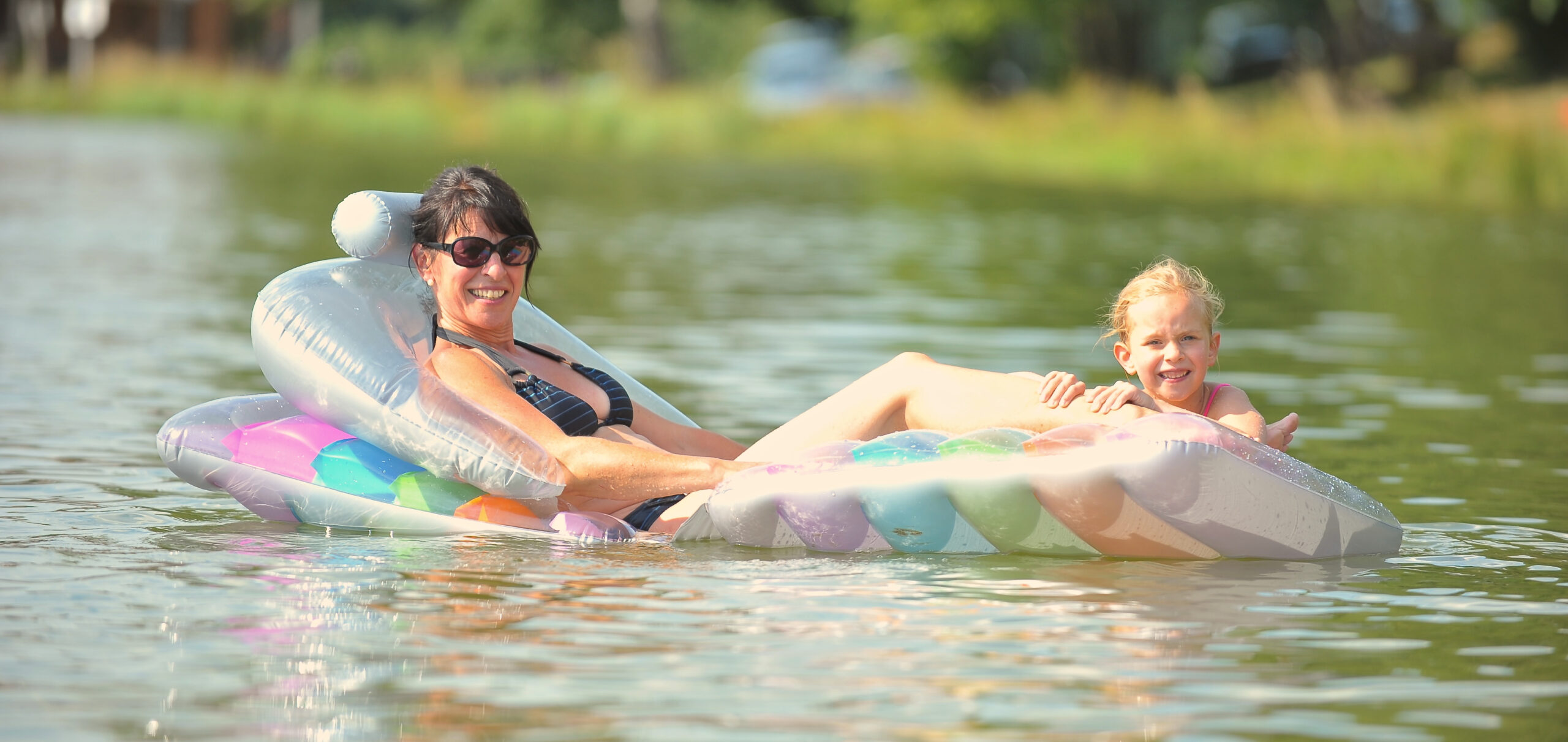 Eine Dame lässt sich auf der Luftmatratze im Wasser treiben